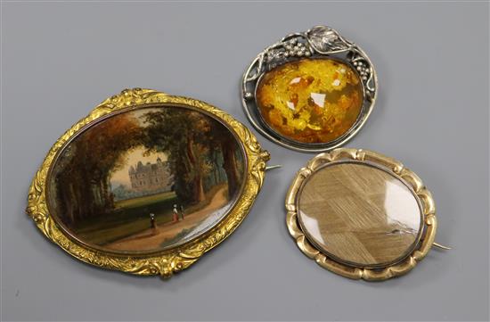 A painted oval panel in gilt metal mount, a yellow metal mourning brooch(a.f.) and an amber set brooch.
